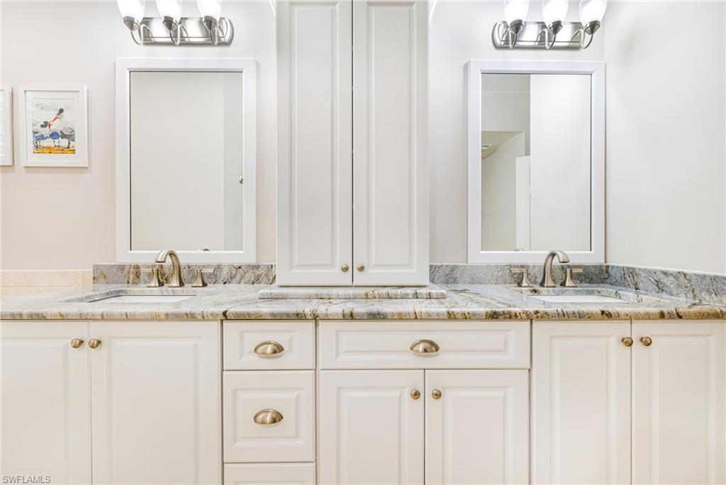 19081 Ridgepoint Drive, Unit 202 Estero, FL 33928 - Photo 26 of 50 a bathroom with a granite countertop sink and a mirror