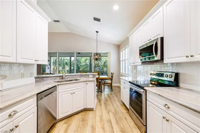 a kitchen with stainless steel appliances granite countertop a stove a sink and a microwave