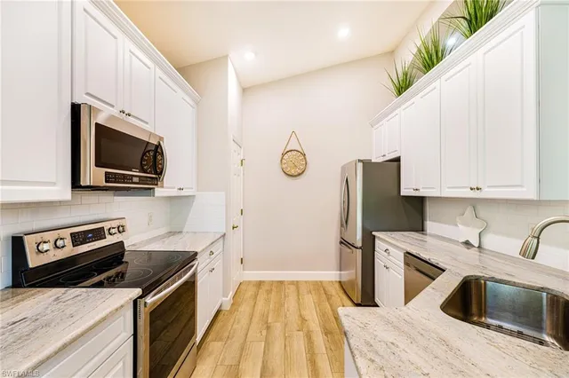 a kitchen with stainless steel appliances a stove a sink a microwave and cabinets