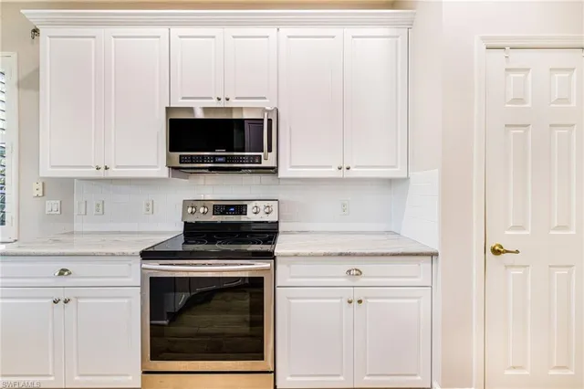 a kitchen with stainless steel appliances white cabinets and a stove