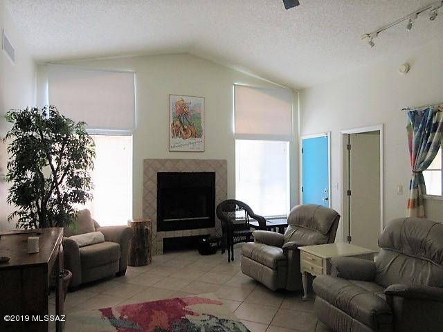 1022 Via Independencia Rio Rico, AZ 85648 - Photo 11 of 41 a living room with furniture a flat screen tv and a fireplace