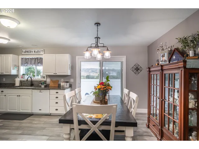 a dining room with furniture a chandelier and wooden floor