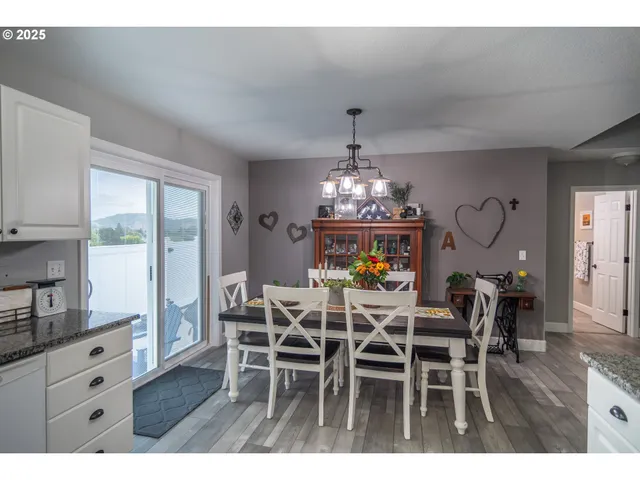a view of a dining room with furniture a chandelier and wooden floor