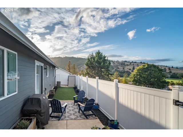 a backyard of a house with table and chairs