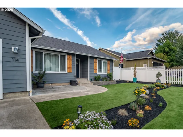 a view of a house with backyard and sitting area