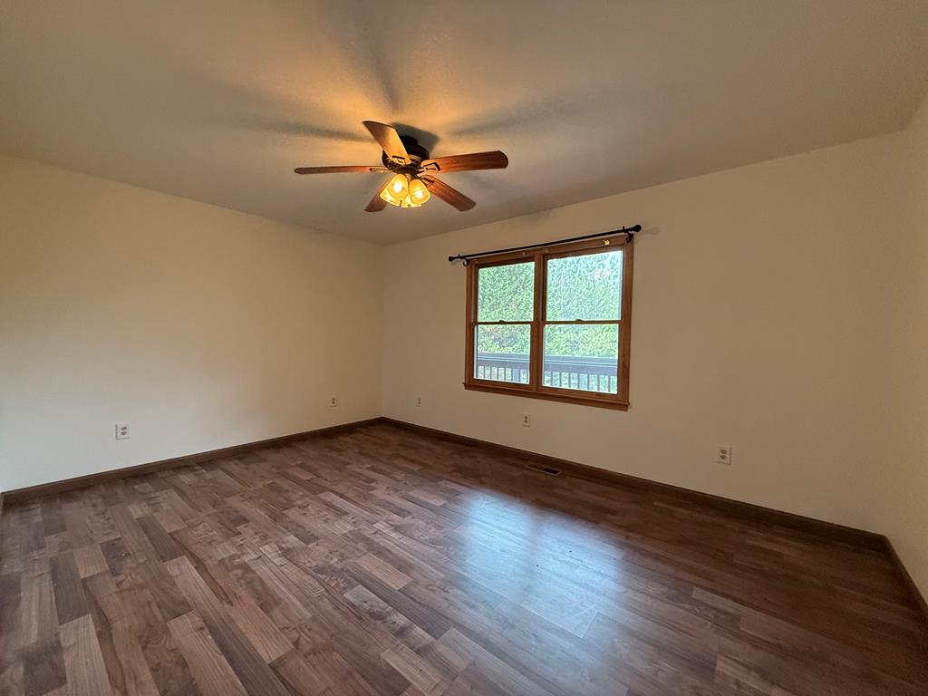 271 Postelle Road Copperhill, TN 37317 - Photo 11 of 59 an empty room with wooden floor fan and windows
