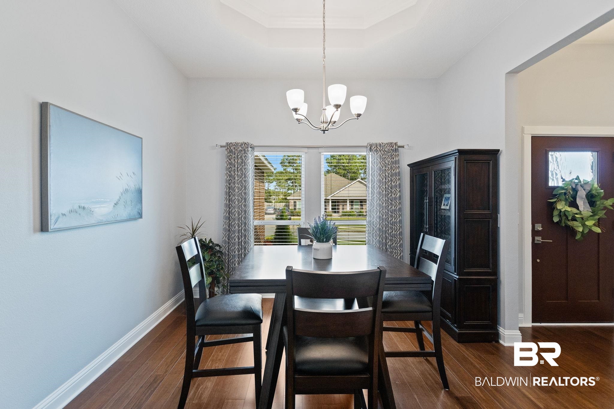 31541 Hoot Owl Road Daphne, AL 36527 - Photo 11 of 51 Dining area featuring a notable chandelier, dark hardwood / wood-style flooring, and a tray ceiling