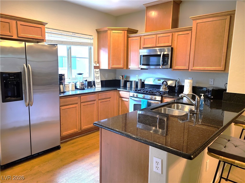 4650 Ranch House Road, Unit 70 North Las Vegas, NV 89031 - Photo 6 of 28 Kitchen featuring stainless steel appliances, a sink, a peninsula, and dark stone countertops