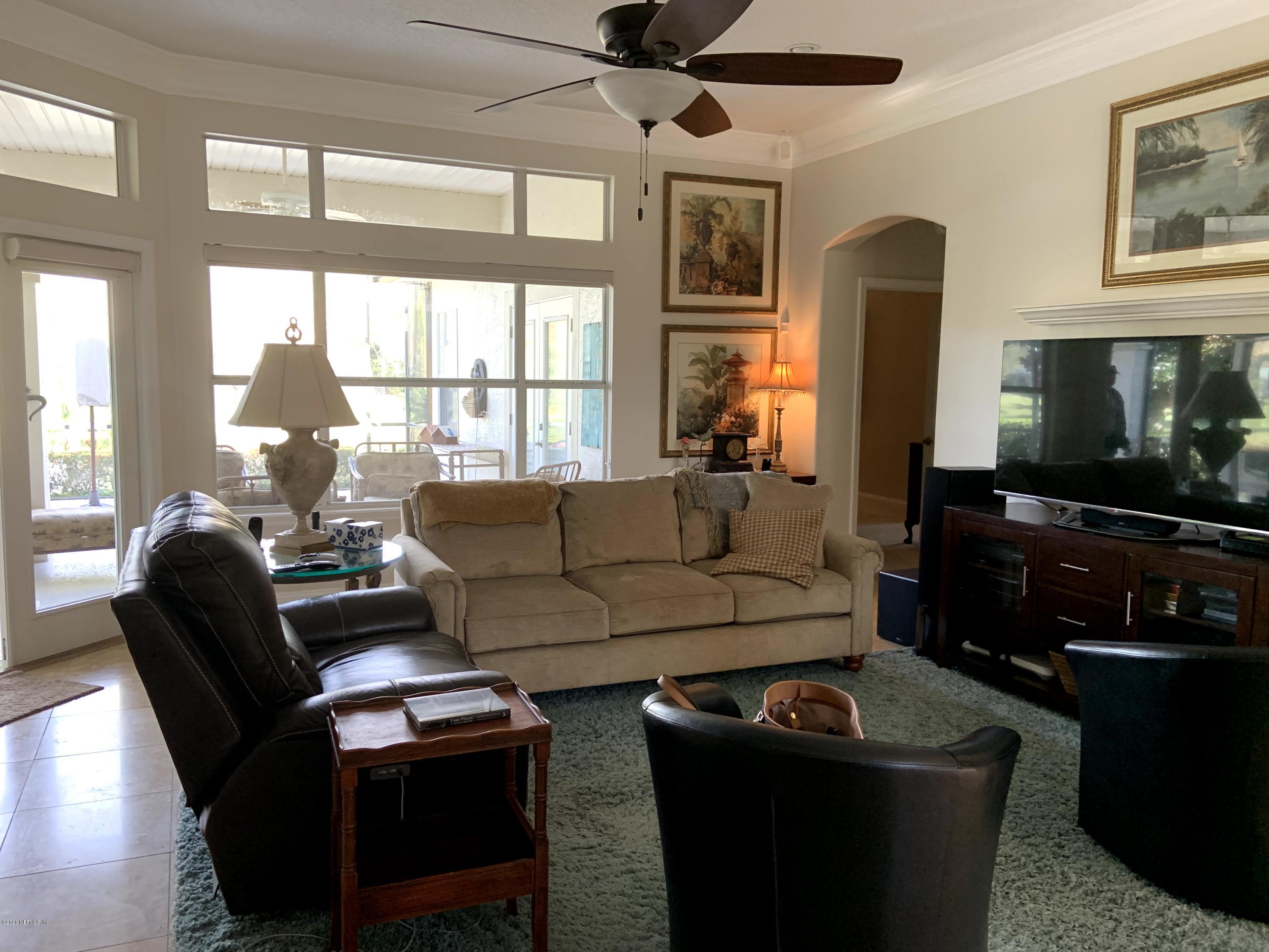 1144 Sandlake Road St. Augustine, FL 32092 - Photo 2 of 11 a living room with furniture a flat screen tv and a floor to ceiling window