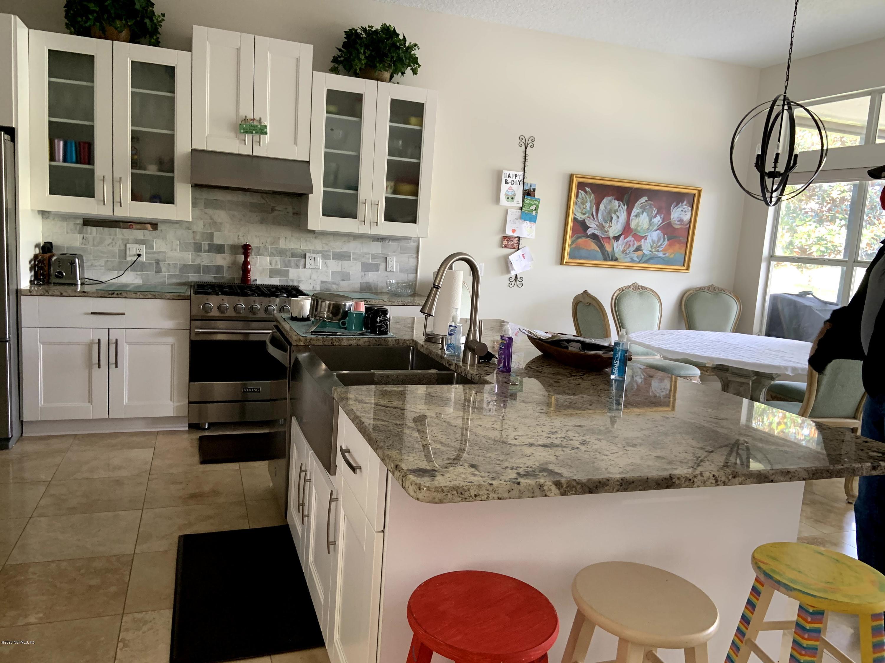1144 Sandlake Road St. Augustine, FL 32092 - Photo 3 of 11 a kitchen with kitchen island granite countertop a stove a sink a refrigerator and cabinets