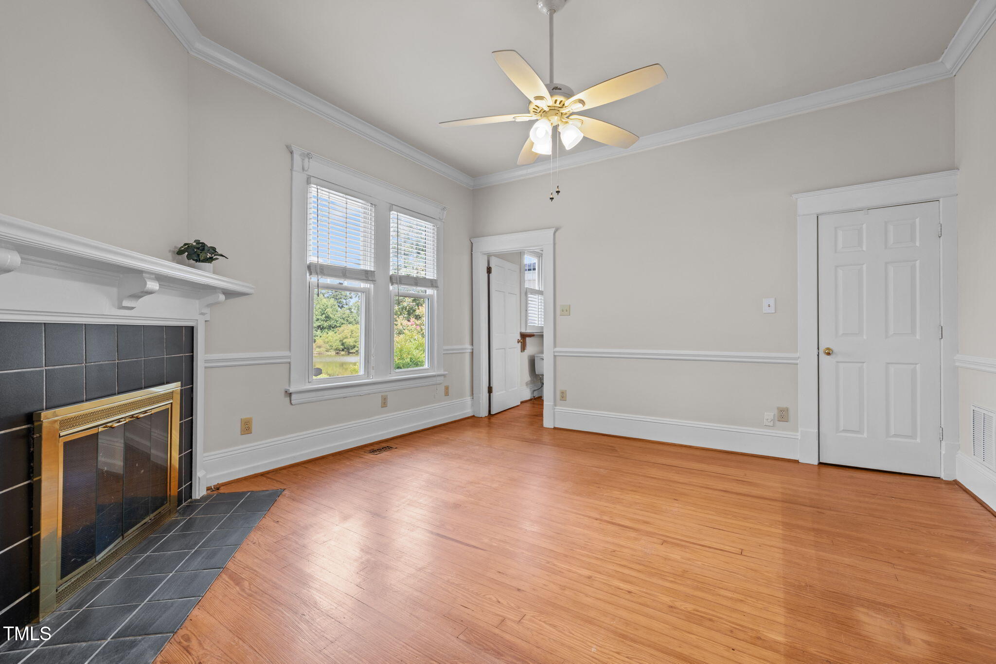 504 Parks Village Road Zebulon, NC 27597 - Photo 15 of 50 an empty room with windows fireplace and fans