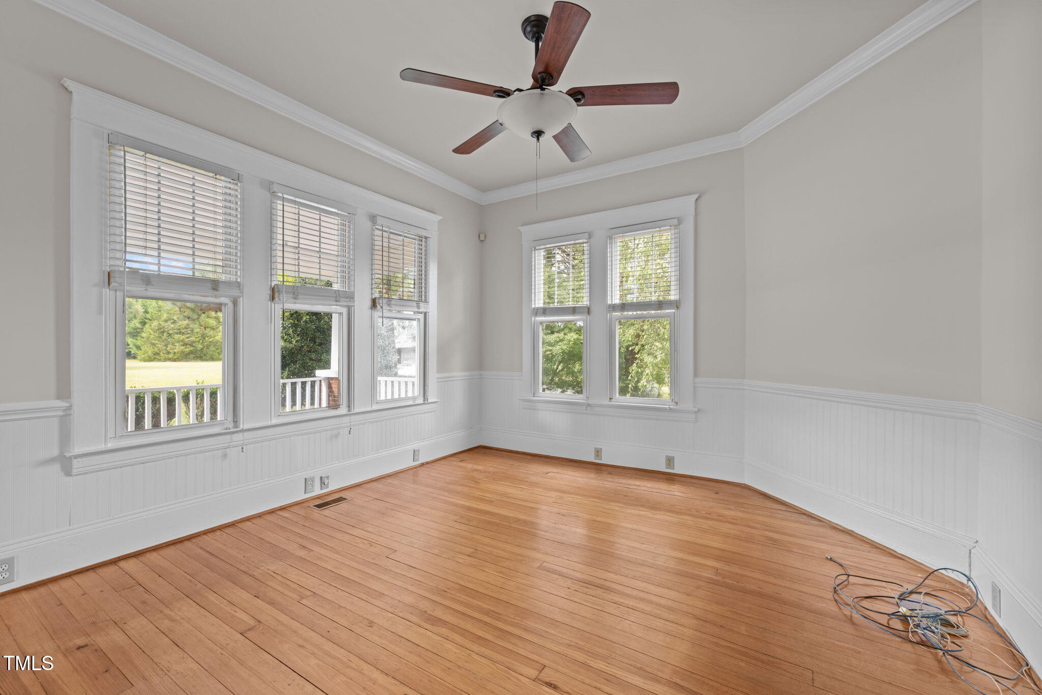 504 Parks Village Road Zebulon, NC 27597 - Photo 7 of 50 an empty room with wooden floor chandelier fan and windows