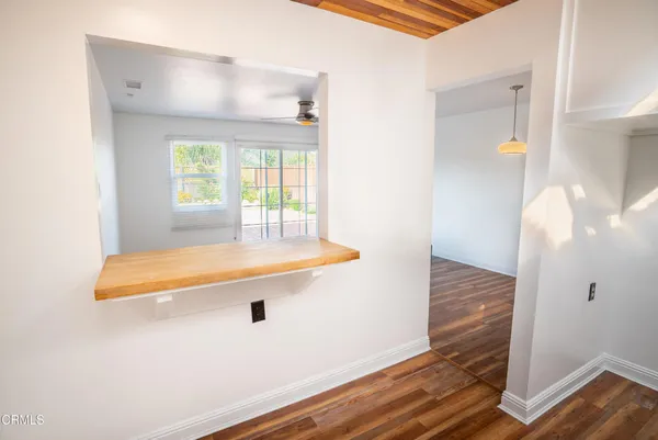 a view of a room with wooden floor and a ceiling fan