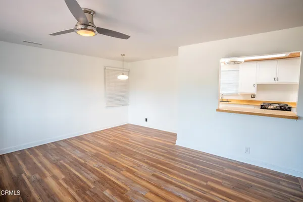a view of an empty room with wooden floor