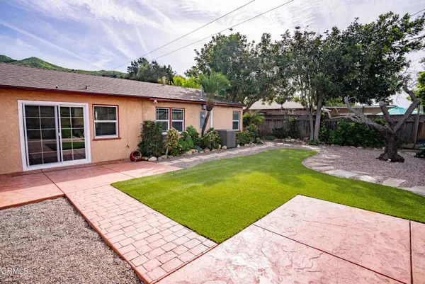 a front view of a house with a yard and trees