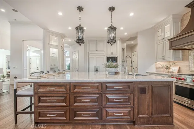 a kitchen with kitchen island granite countertop a sink and cabinets