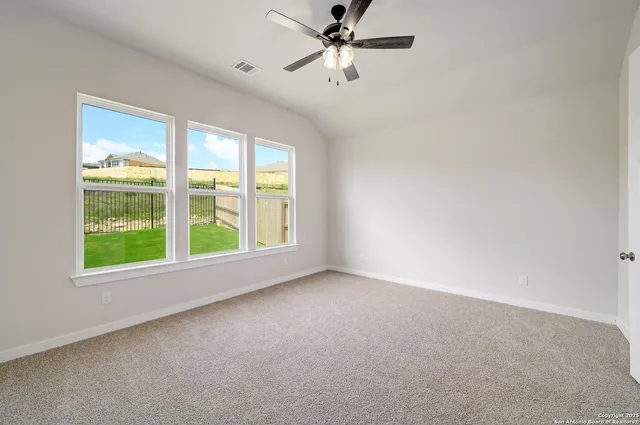 an empty room with a window and a ceiling fan
