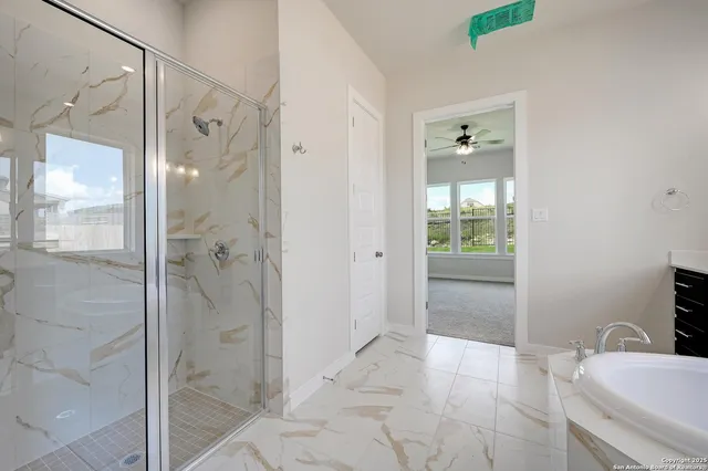 a bathroom with a granite countertop shower mirror and a bathtub