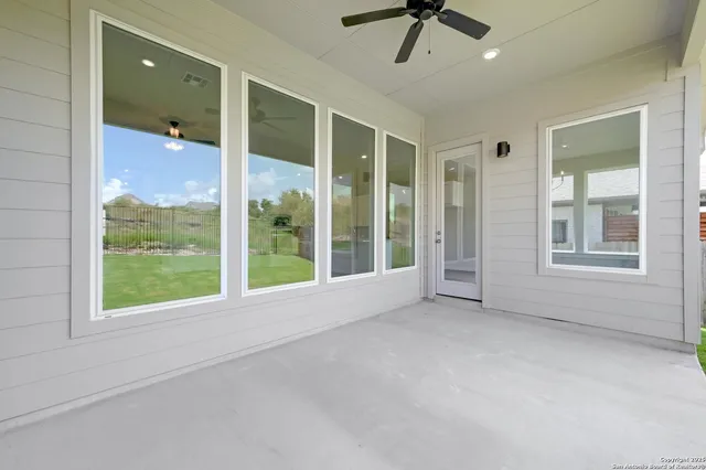 a view of an empty room with a window and a ceiling fan