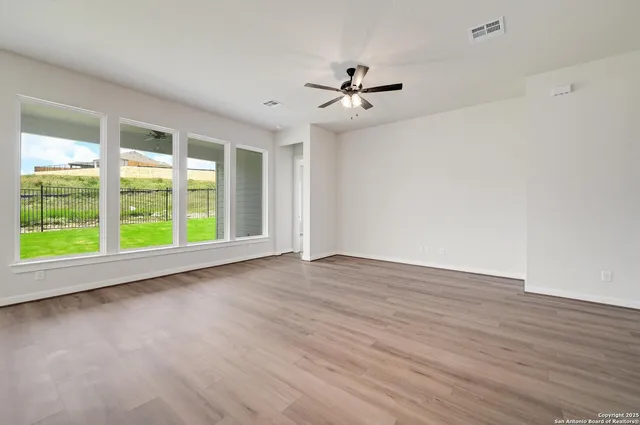 a view of room with window ceiling fan and hardwood floor