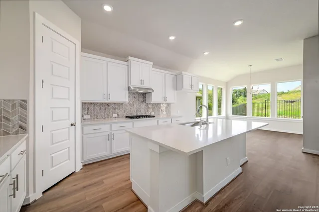 a kitchen with granite countertop white cabinets and white appliances