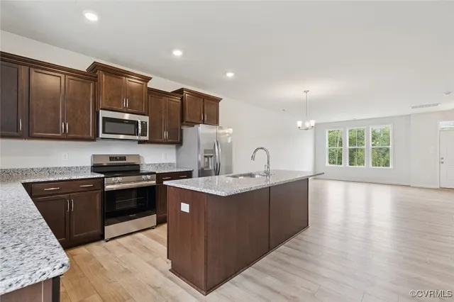 a kitchen with stainless steel appliances granite countertop a sink refrigerator and microwave