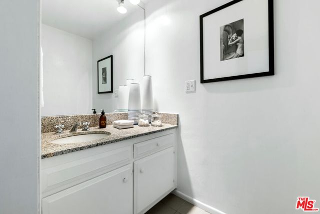 a bathroom with a granite countertop sink mirror and vanity