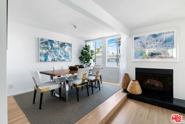 a dining room with furniture a fireplace and wooden floor