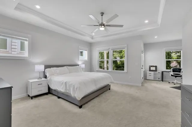 a spacious bedroom with a bed a couch and a window