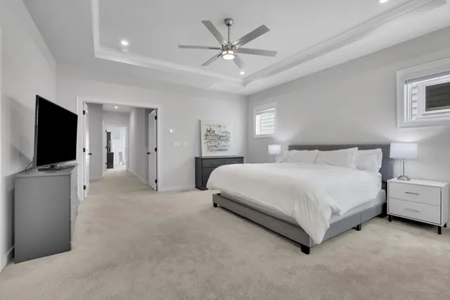 a spacious bedroom with a bed and a flat screen tv