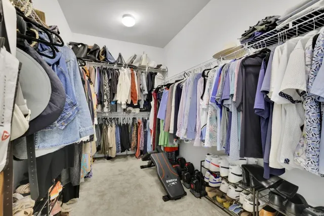 a view of walk in closet with clothes