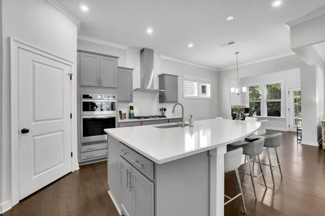 a kitchen with stainless steel appliances kitchen island a table chairs refrigerator and cabinets