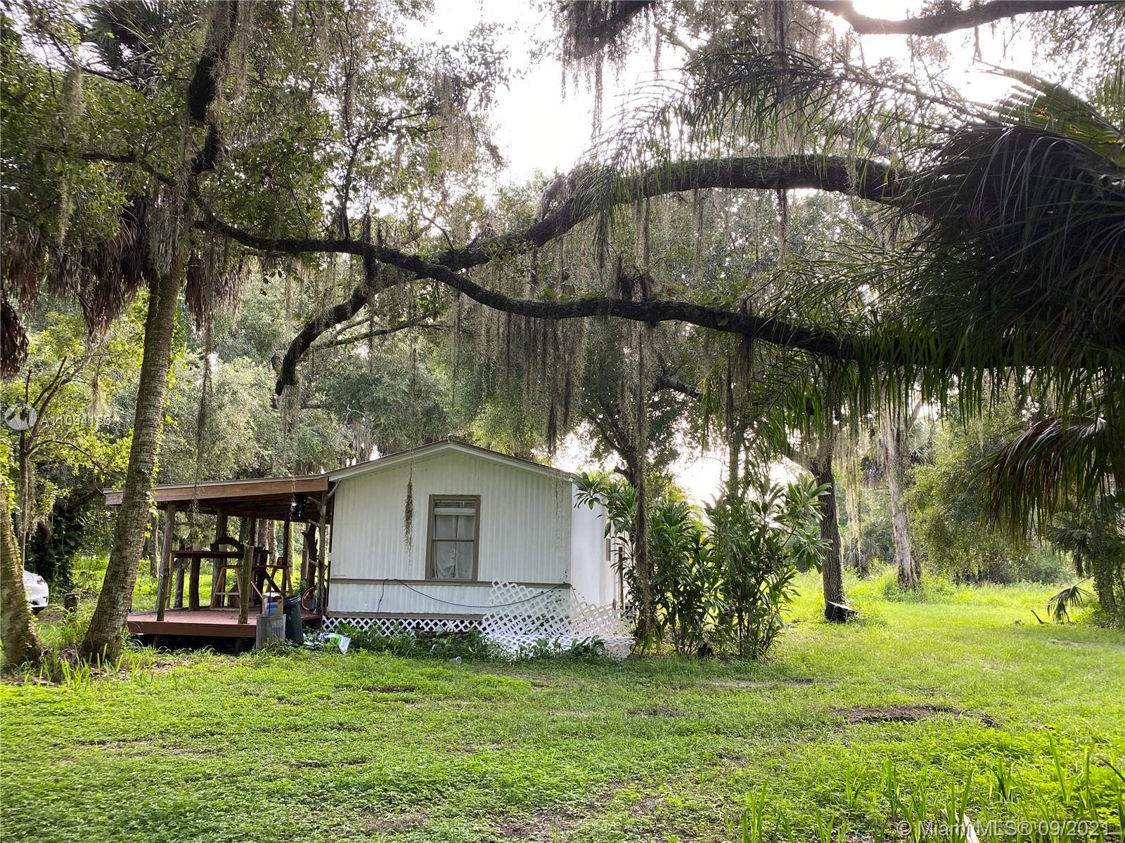 1600 G Road LaBelle, FL 33935 - Photo 4 of 7 a backyard of a house with table and chairs and a large tree