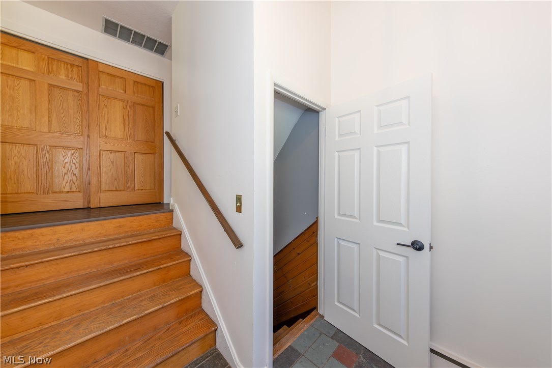 7969 Dines Road Novelty, OH 44072 - Photo 2 of 48 Foyer featuring wood steps a wood-finish handrail, paneled closet doors, and light wall finishes