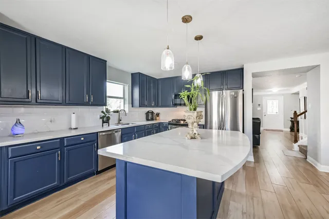 a kitchen with a sink a counter space and wooden floor