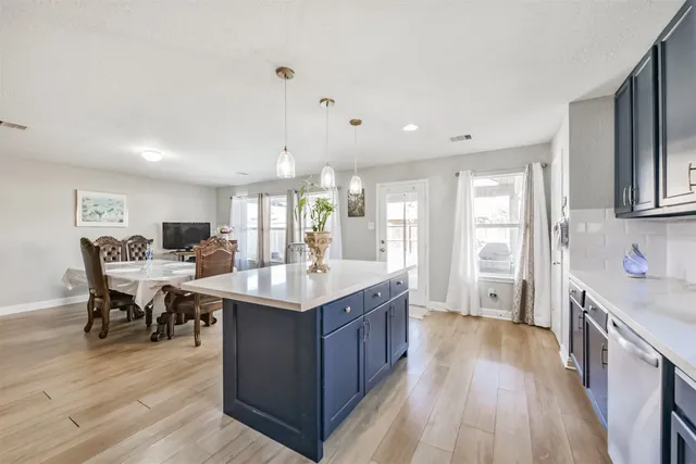 a kitchen with stainless steel appliances granite countertop a lot of counter space and wooden floor