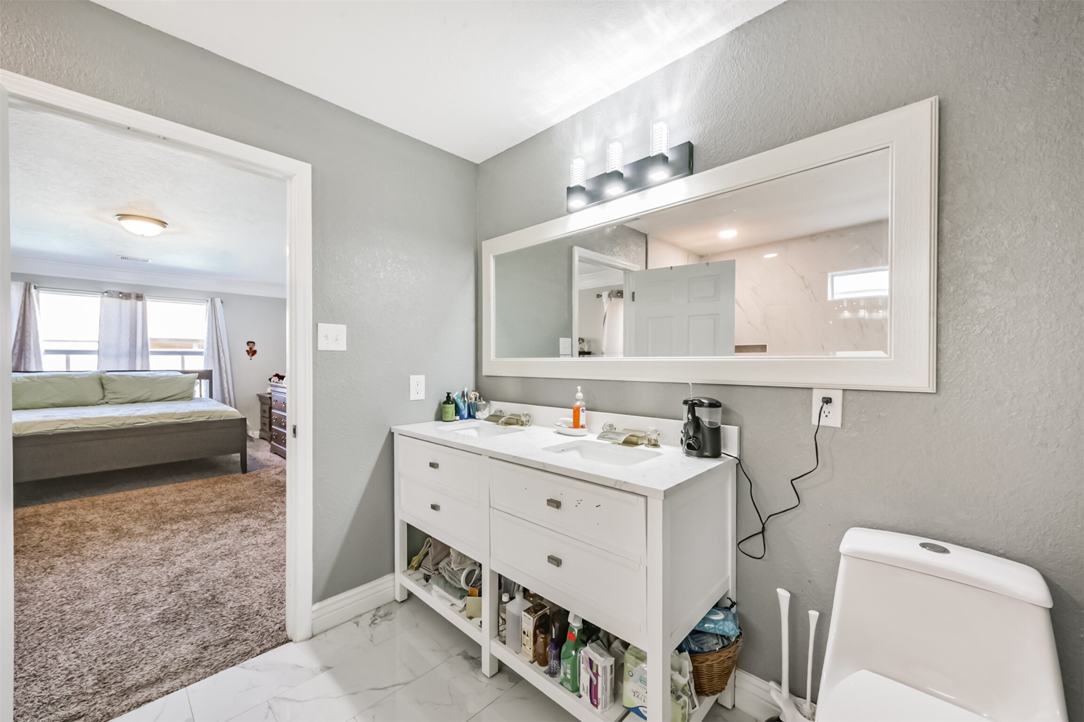 7015 Falling Cherry Place Houston, TX 77049 - Photo 21 of 42 a bathroom with a sink a toilet a mirror and a bathtub