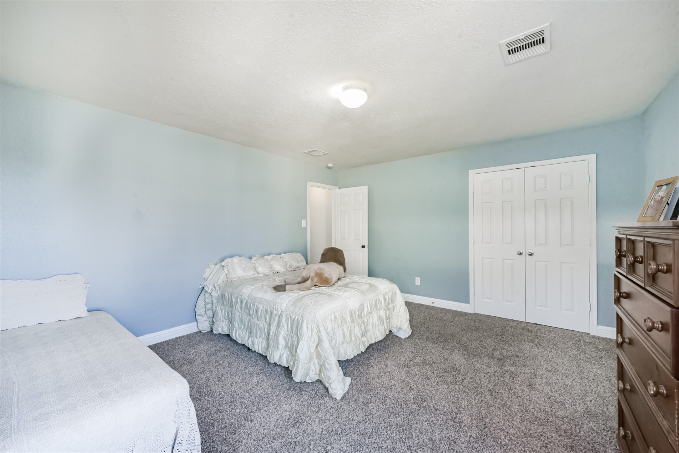 7015 Falling Cherry Place Houston, TX 77049 - Photo 31 of 42 a bedroom with a bed and a lamp