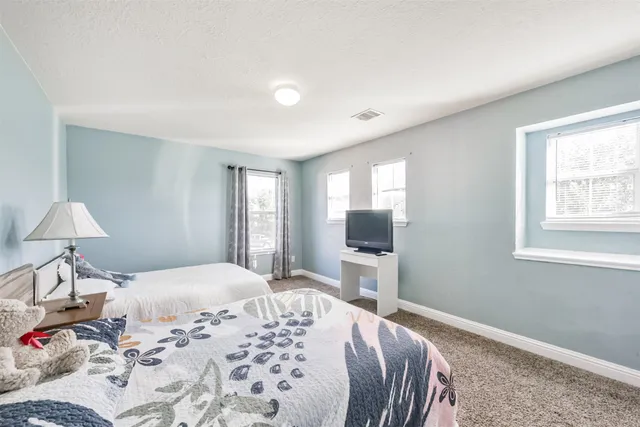 a bedroom with two bed and a flat screen tv