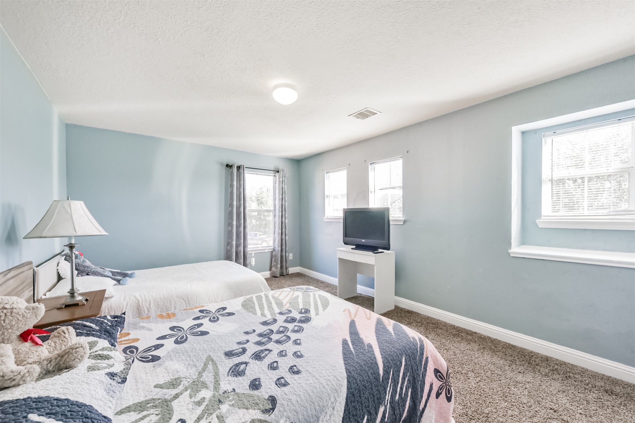 7015 Falling Cherry Place Houston, TX 77049 - Photo 32 of 42 a bedroom with a bed and a flat screen tv