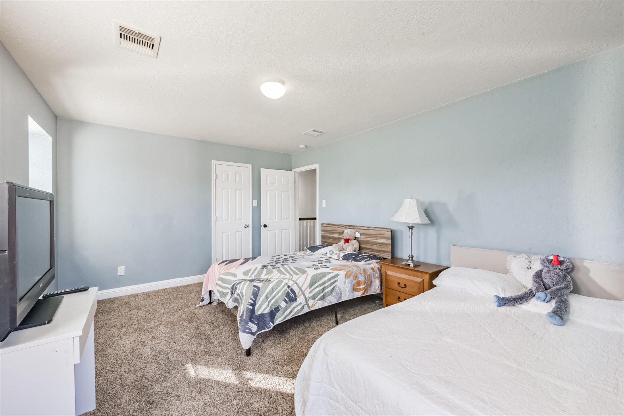 7015 Falling Cherry Place Houston, TX 77049 - Photo 33 of 42 a bedroom with two bed and a flat screen tv