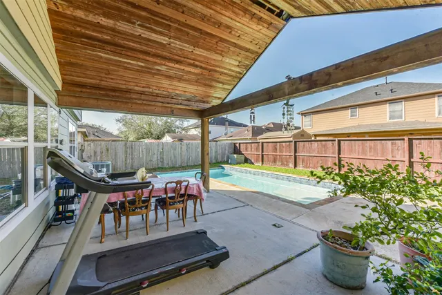 a view of a patio with table and chairs potted plants and floor to ceiling window