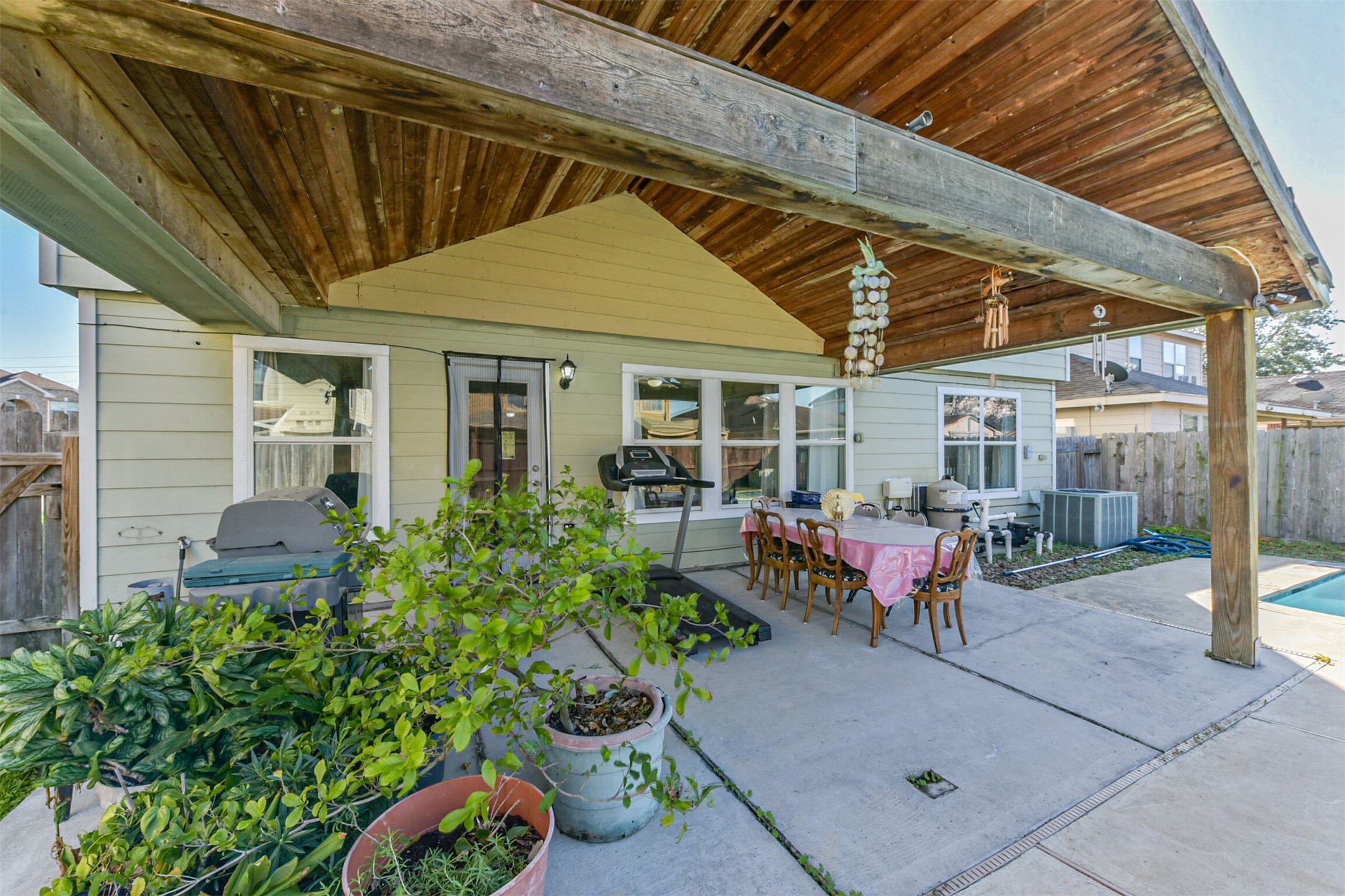 7015 Falling Cherry Place Houston, TX 77049 - Photo 37 of 42 a view of a patio with table and chairs potted plants and floor to ceiling window