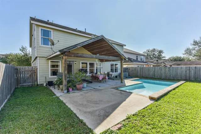 a view of a house with swimming pool and sitting area
