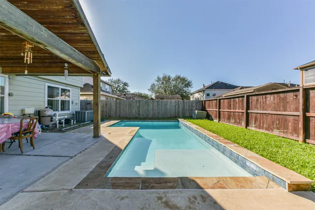 a view of a patio with table and chairs potted plants and floor to ceiling window and potted plants