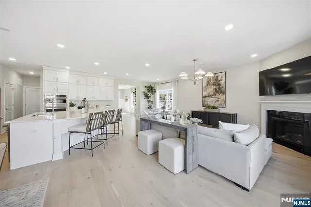a living room with furniture a flat screen tv and kitchen view