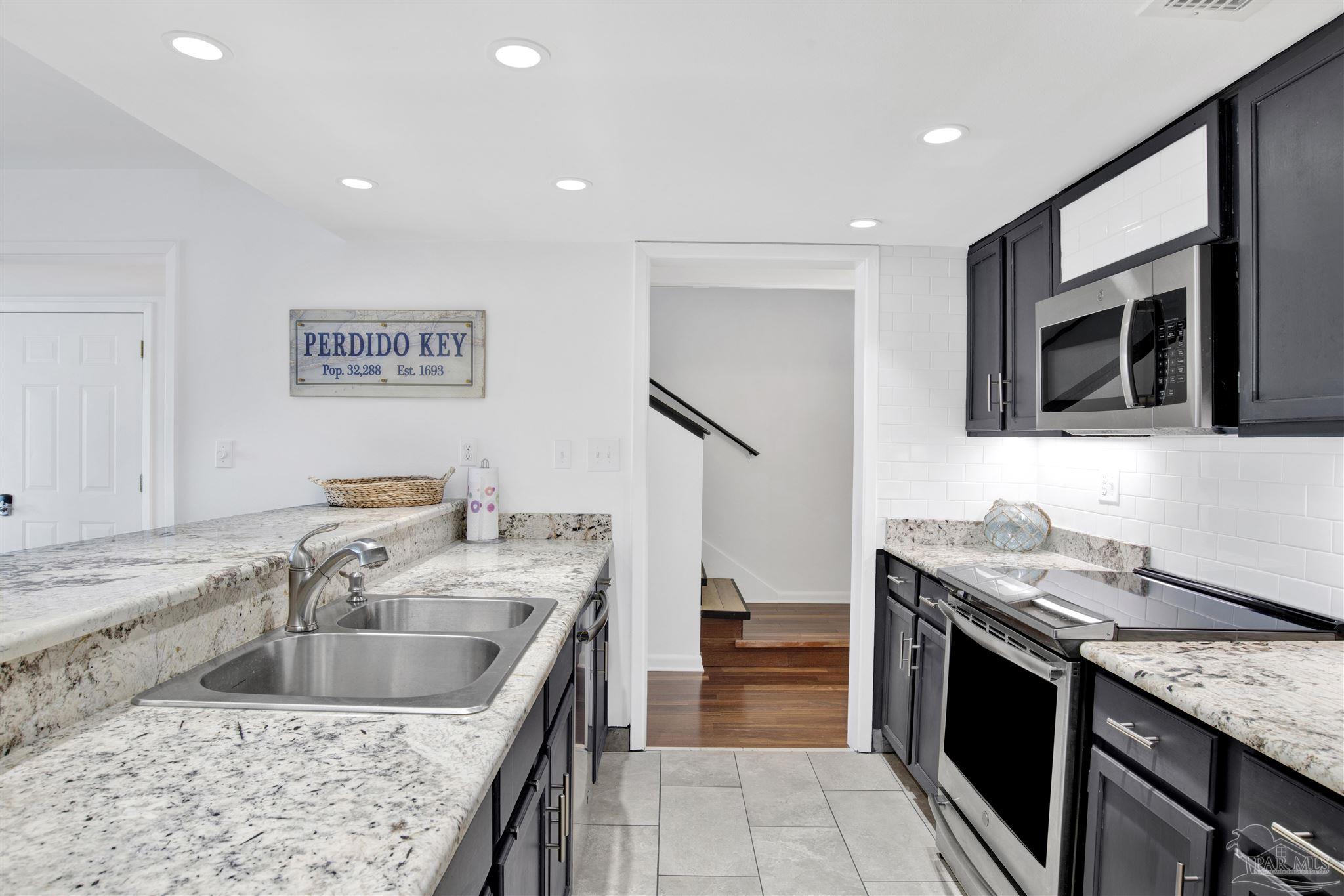 16784 Perdido Key Drive, Unit 9 Pensacola, FL 32507 - Photo 11 of 48 a kitchen that has a sink and a stove in it