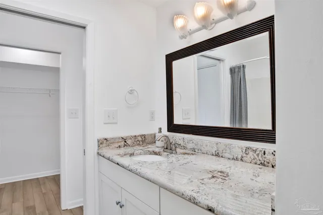 a bathroom with a granite countertop sink and a mirror