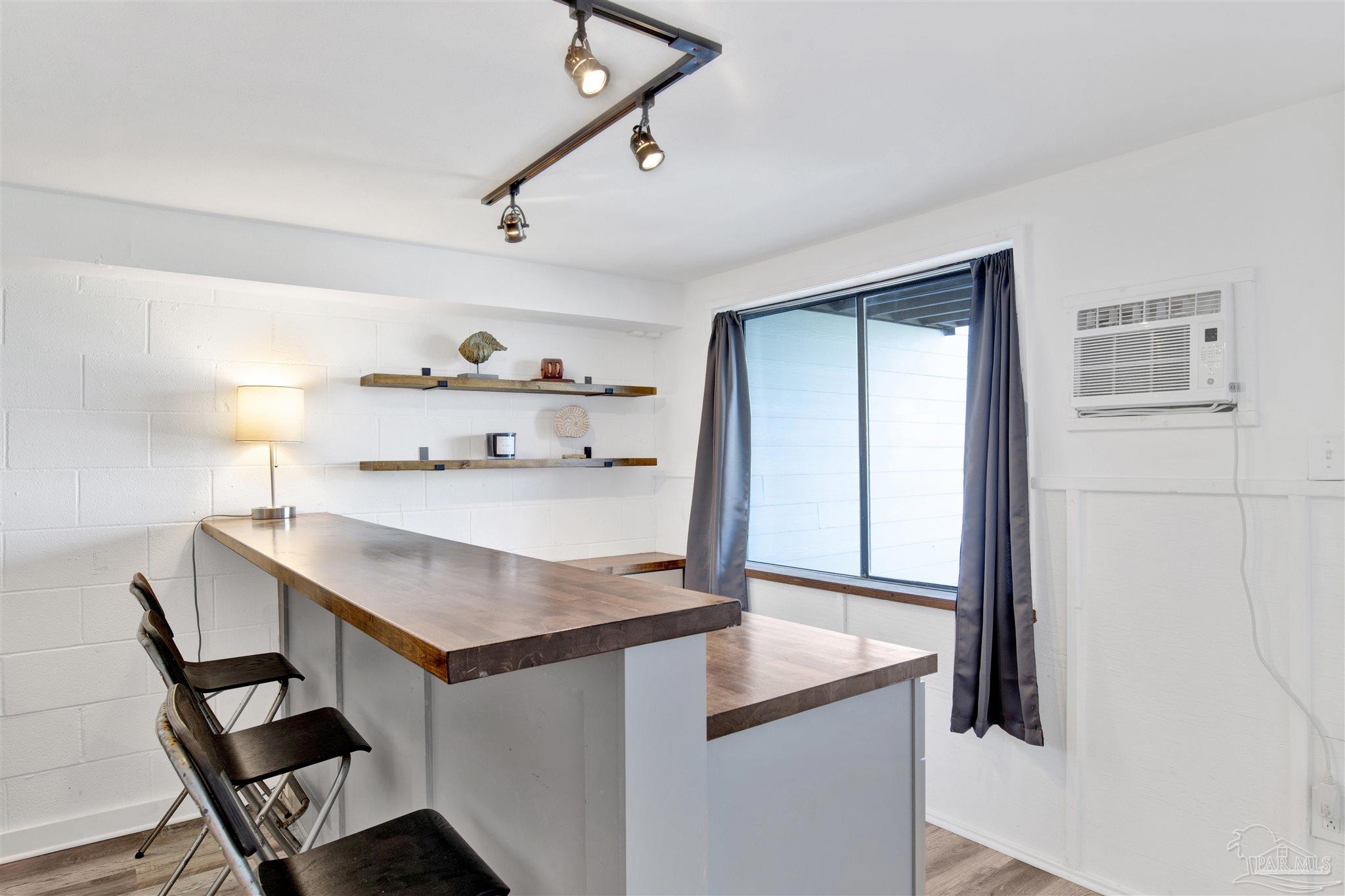 16784 Perdido Key Drive, Unit 9 Pensacola, FL 32507 - Photo 22 of 48 a room with a table chairs and wooden floor