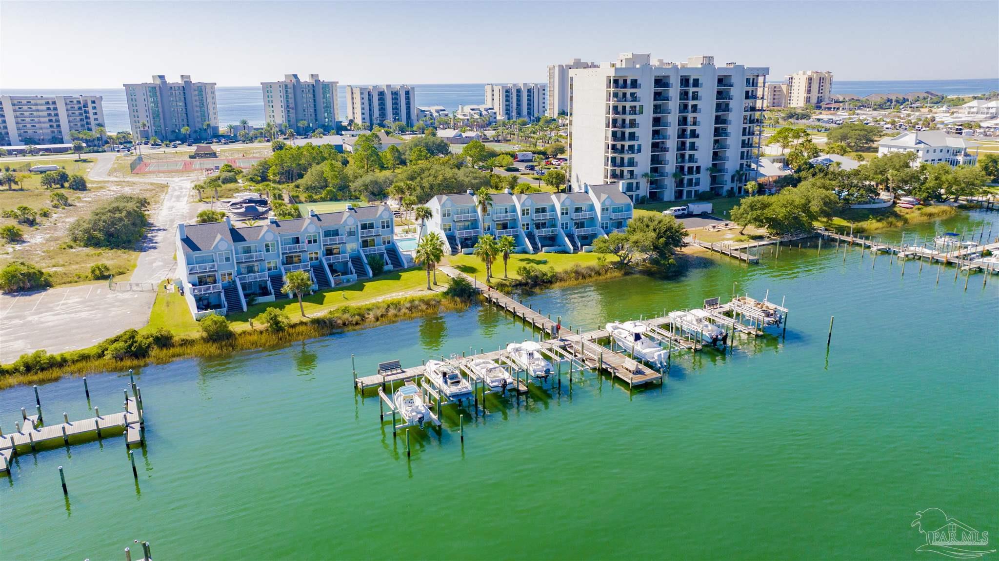 16784 Perdido Key Drive, Unit 9 Pensacola, FL 32507 - Photo 42 of 48 a view of a swimming pool with outdoor seating and a garden